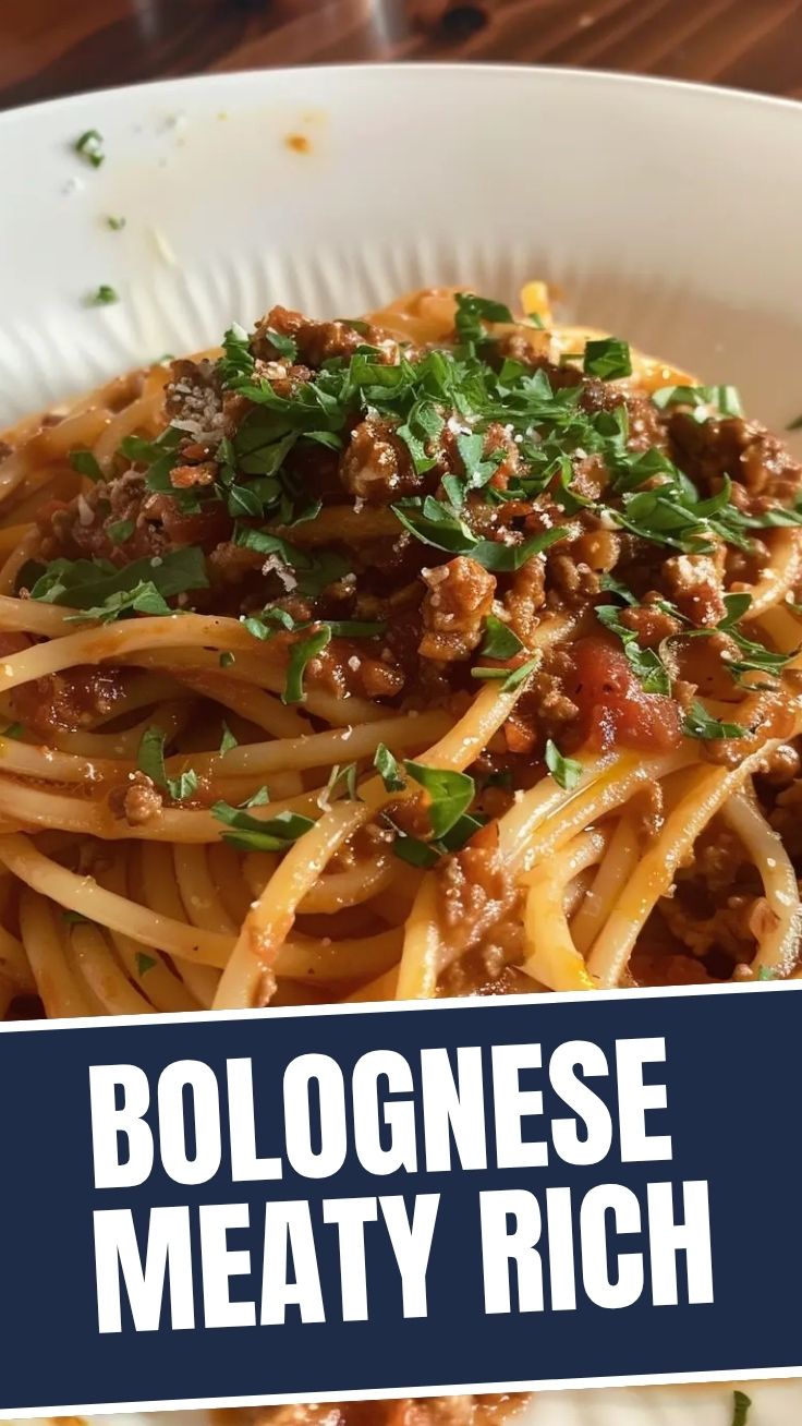 A steaming plate of spaghetti bolognese topped with fresh basil.